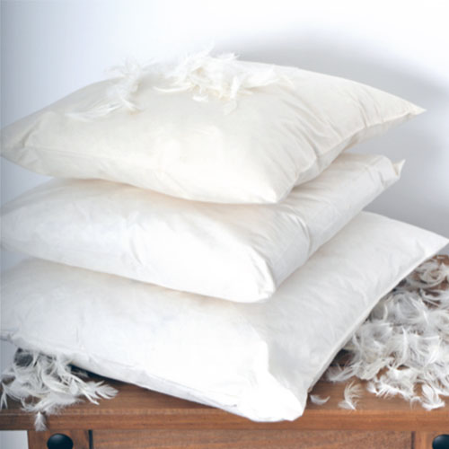 three white cushions with feathers